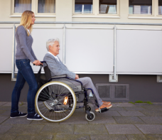 elder female in wheelchair and staff